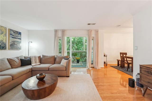 living room with light wood-style floors and visible vents