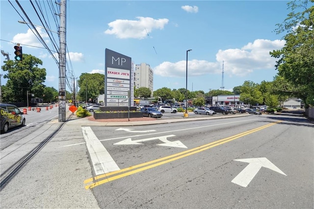 view of road featuring street lighting, curbs, and sidewalks