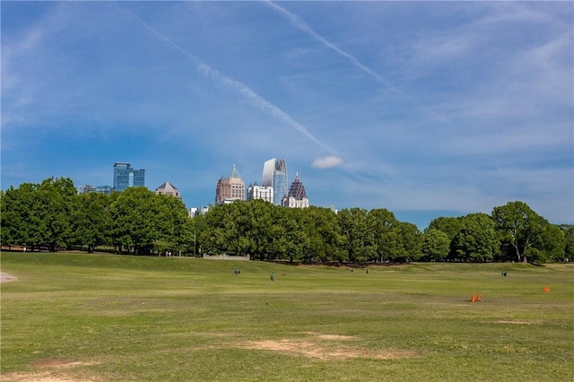 view of community featuring a view of city and a yard