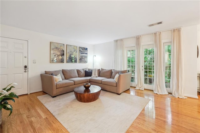 living room with light wood-style floors and visible vents