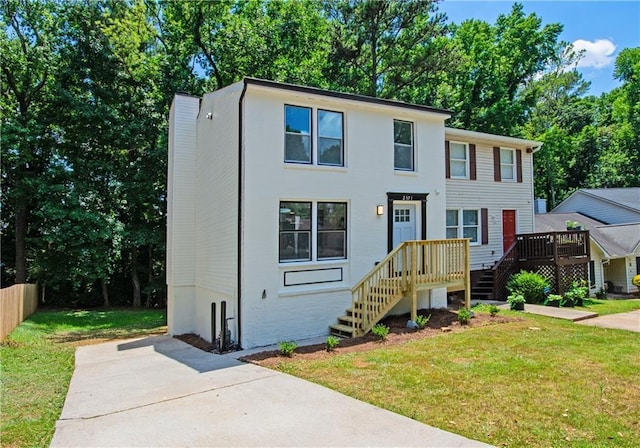 view of front of house with a deck and a front lawn