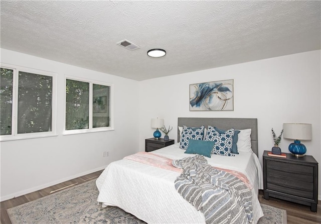 bedroom featuring hardwood / wood-style floors and a textured ceiling