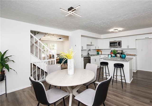 dining room with a textured ceiling, dark hardwood / wood-style floors, and sink