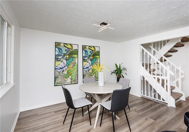 dining area featuring a textured ceiling and hardwood / wood-style flooring