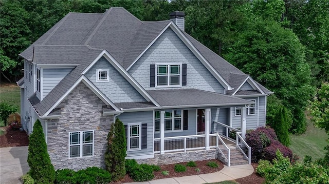 214 Westwind Dr, Newnan, GA 30263 - view of front of home featuring covered porch, a chimney, stone siding, and a shingled roof