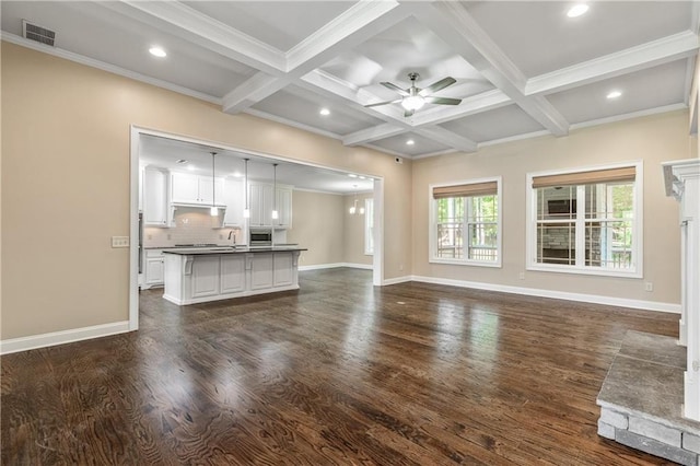 214 Westwind Dr, Newnan, GA 30263 - unfurnished living room featuring dark wood-style flooring, ceiling fan, beamed ceiling, coffered ceiling, and crown molding