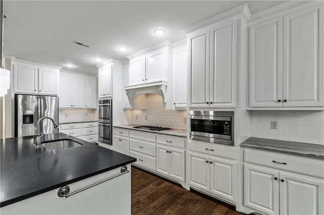 214 Westwind Dr, Newnan, GA 30263 - kitchen featuring stainless steel appliances, a sink, dark countertops, recessed lighting, and white cabinetry