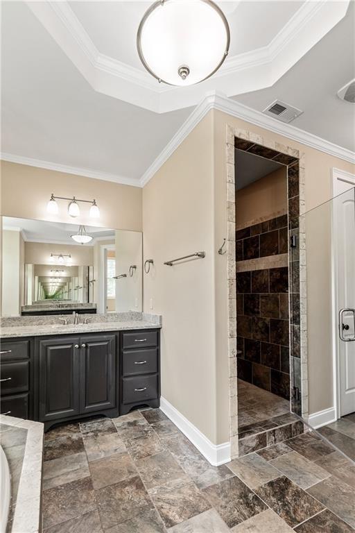 214 Westwind Dr, Newnan, GA 30263 - bathroom featuring baseboards, a tile shower, vanity, crown molding, and a raised ceiling