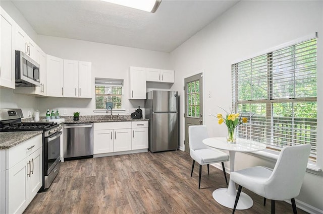 3440 Oaktree Way, Stonecrest, GA 30038 - kitchen with appliances with stainless steel finishes, white cabinetry, stone counters, and dark wood-type flooring