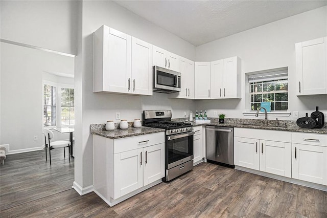 3440 Oaktree Way, Stonecrest, GA 30038 - kitchen with stainless steel appliances, dark stone countertops, dark wood finished floors, and white cabinets
