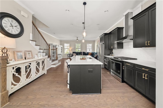 20057 Windalier Way, Roswell, GA 30076 - kitchen with appliances with stainless steel finishes, dark cabinets, wall chimney exhaust hood, open floor plan, and light countertops
