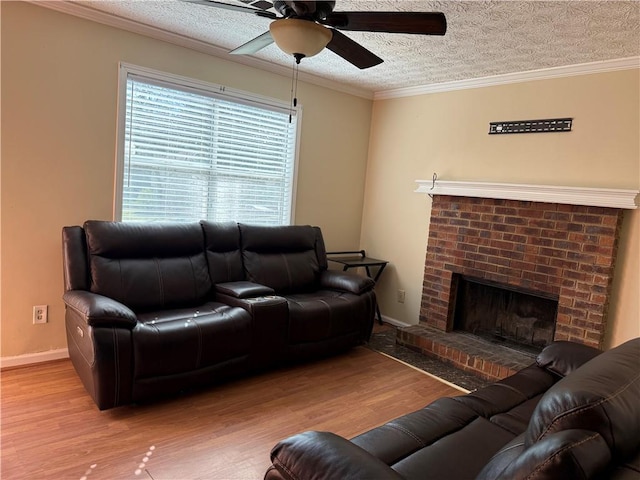 living room with crown molding, wood finished floors, a fireplace, a textured ceiling, and a ceiling fan