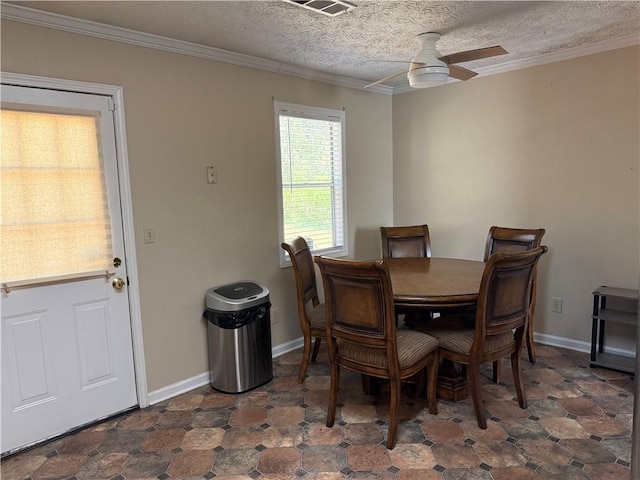 dining space featuring baseboards, ornamental molding, a textured ceiling, and a ceiling fan