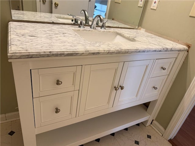 bathroom with baseboards, marble finish floor, and vanity