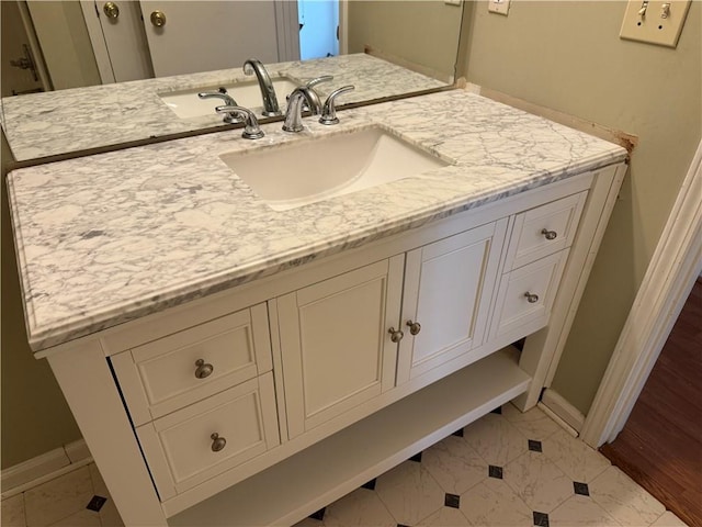 bathroom with baseboards, marble finish floor, and vanity
