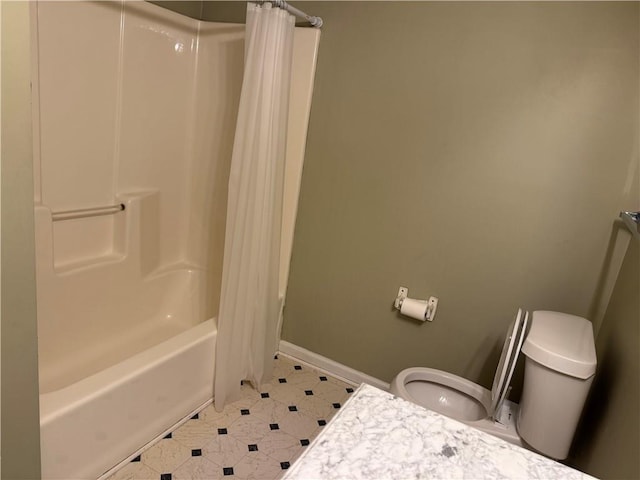 full bath featuring baseboards, toilet, and shower / tub combo