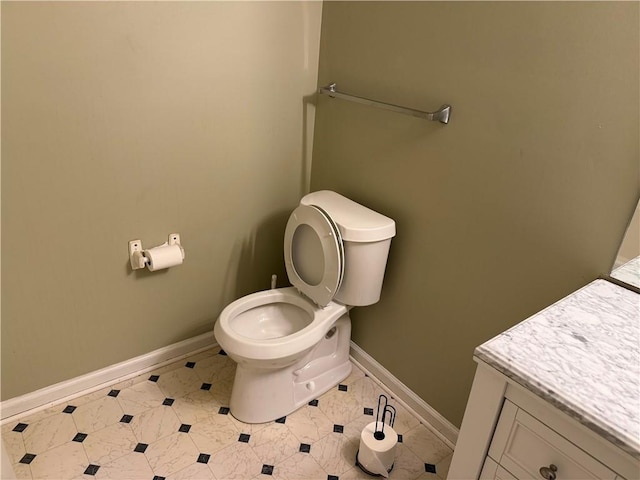 bathroom with toilet, baseboards, tile patterned floors, and vanity