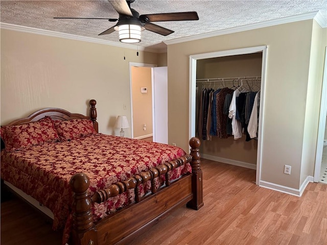 bedroom with a textured ceiling, ornamental molding, a closet, and light wood-style flooring