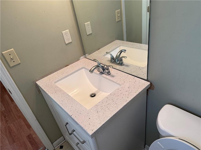 bathroom with vanity, toilet, and wood finished floors