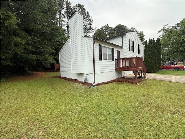 view of side of property with a chimney and a yard