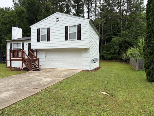 tri-level home featuring a garage, a front lawn, a chimney, and concrete driveway