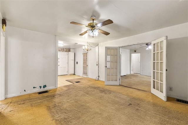 unfurnished room featuring visible vents, baseboards, carpet, french doors, and ceiling fan with notable chandelier