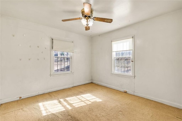 empty room featuring carpet floors, plenty of natural light, baseboards, and ceiling fan