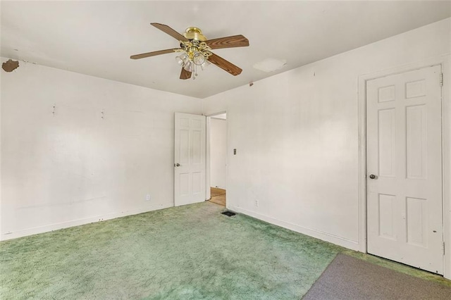 carpeted empty room with baseboards and a ceiling fan