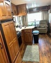 kitchen with black appliances and dark wood-type flooring