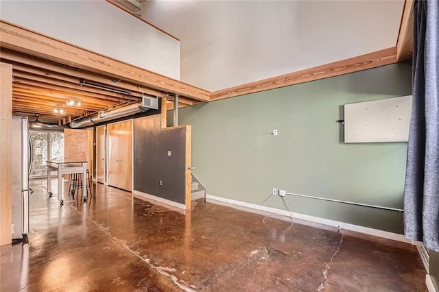 basement featuring stainless steel refrigerator