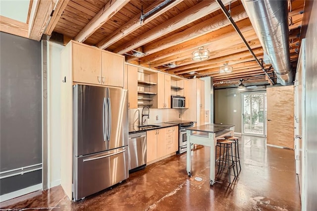 kitchen featuring appliances with stainless steel finishes, sink, and a breakfast bar area