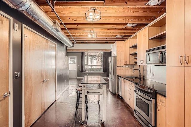 kitchen with sink, appliances with stainless steel finishes, a kitchen breakfast bar, a kitchen island, and light brown cabinets