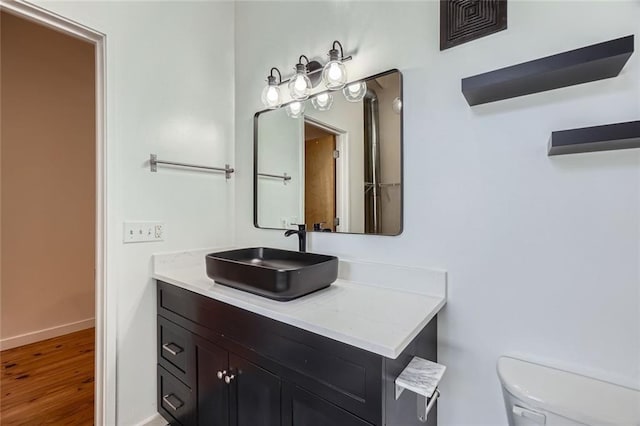 bathroom with vanity, hardwood / wood-style flooring, and toilet