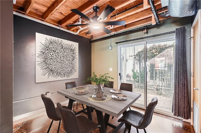 dining space with beam ceiling, concrete flooring, and ceiling fan