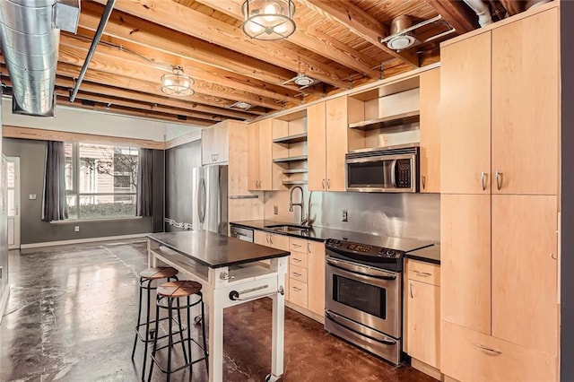 kitchen with sink, light brown cabinets, a breakfast bar, and appliances with stainless steel finishes