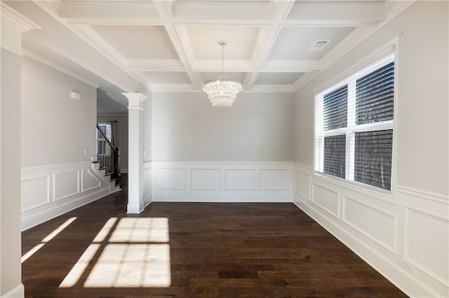 unfurnished dining area featuring dark wood-type flooring, coffered ceiling, an inviting chandelier, beam ceiling, and decorative columns