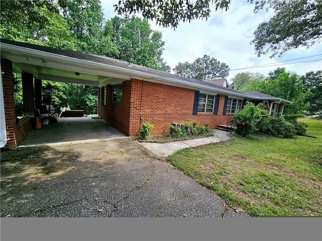 2480 Sewell Mill Rd, Marietta, GA 30062 - view of side of property with asphalt driveway, brick siding, an attached carport, and a yard
