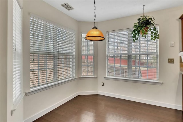 unfurnished dining area featuring dark wood-type flooring