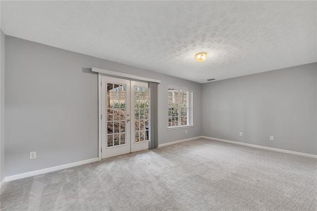 empty room with carpet and a textured ceiling