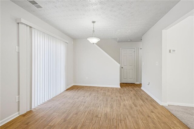 interior space featuring a textured ceiling and light hardwood / wood-style flooring