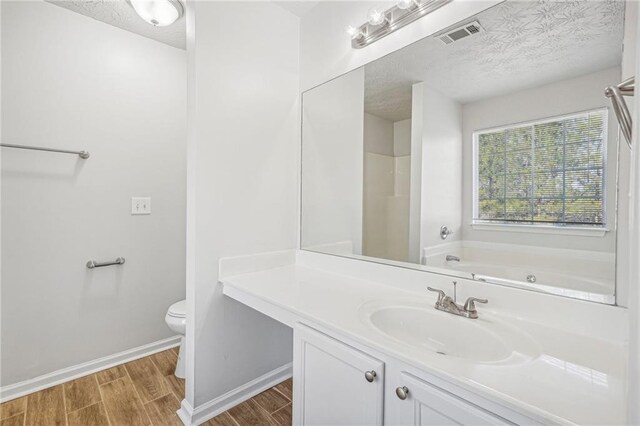 full bathroom with toilet, vanity, a textured ceiling, and hardwood / wood-style flooring