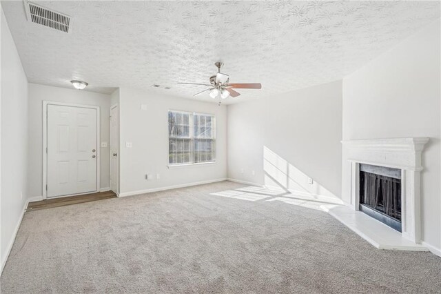 unfurnished living room featuring ceiling fan, light colored carpet, and a textured ceiling