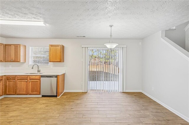 kitchen featuring pendant lighting, stainless steel dishwasher, plenty of natural light, and sink