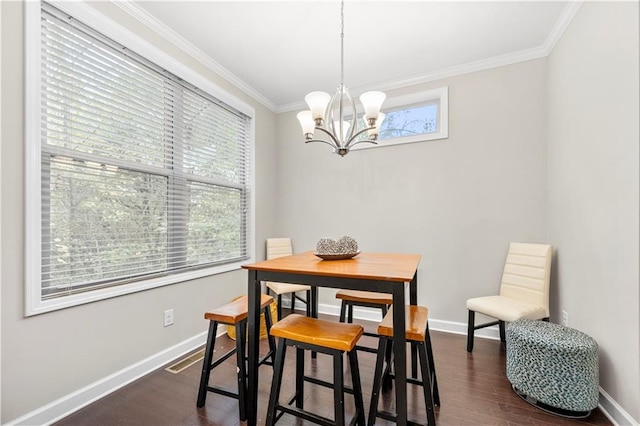 dining room featuring ornamental molding, dark hardwood / wood-style floors, and an inviting chandelier