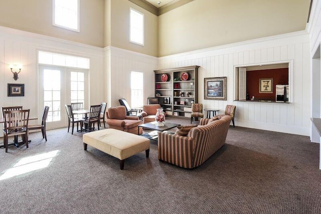 carpeted living room with a towering ceiling