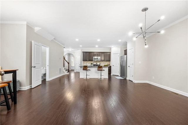 living room with crown molding, dark hardwood / wood-style flooring, and an inviting chandelier