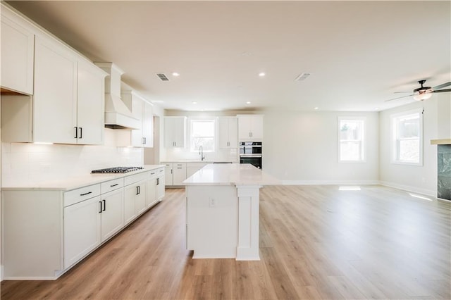 4202 Adler Cir, Buford, GA 30519 - kitchen with backsplash, white cabinetry, premium range hood, and visible vents