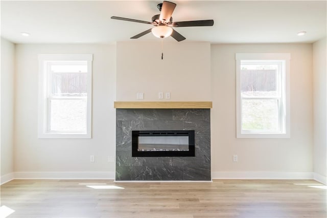 4202 Adler Cir, Buford, GA 30519 - unfurnished living room with a high end fireplace, light wood finished floors, ceiling fan, and baseboards