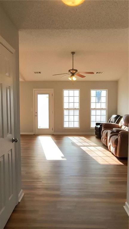 doorway to outside with visible vents, ceiling fan, a textured ceiling, and wood finished floors