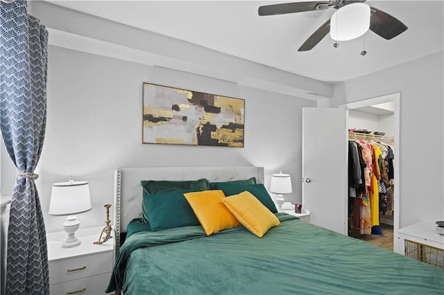 bedroom with a spacious closet, a closet, and a ceiling fan